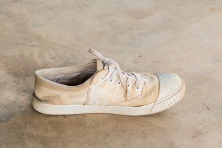 Old white sneaker on  cement floorの写真素材