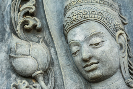close up face of statue on the wall in temple , Thailandの写真素材