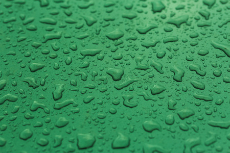 Drop water rain on the green car in close up background and texturesの写真素材