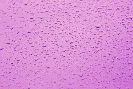 Drop water rain on the purple car in close up background and texturesの写真素材