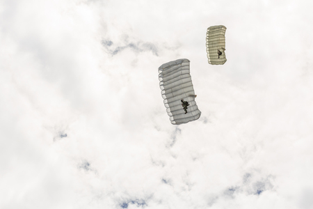 Parachutist descends and trains in landing accuracy that parachute fly on sky with white cloud in dayの写真素材