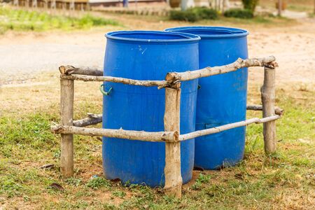 Two Blue Trash bins  in wooden fenceの写真素材