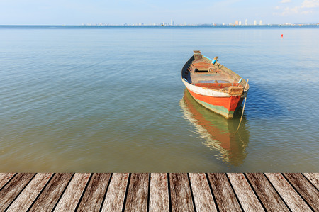 old wood fishing boat at anchor in sea background and mock upの写真素材
