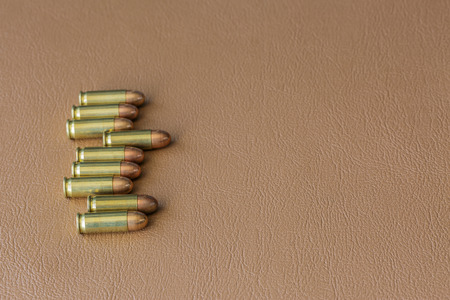 Nine bullets on brown leather