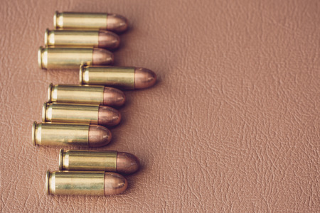 Nine bullets on brown leather
