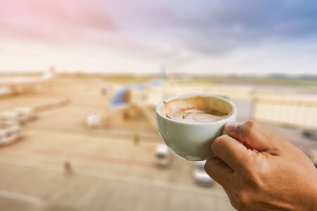 cup of coffee in the hands at blurred airport  backgroundの写真素材