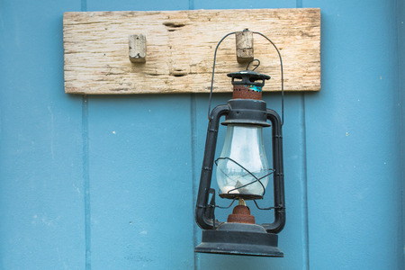 Burning kerosene lamp hang on the wooden wallの写真素材
