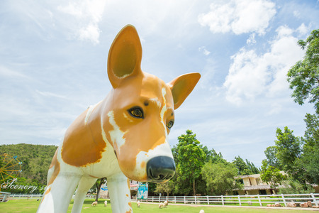 RATCHABURI, THAILAND  SEPTEMBER 18, 2017 : Statue of a big dog standing amout sheeps in park at The Scnery Vintage Farm in Suanpeung Ratchaburi Thailand.のeditorial素材