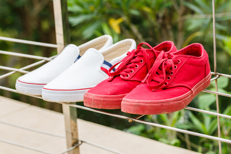 Red man sneakers and white sneakers womanの写真素材