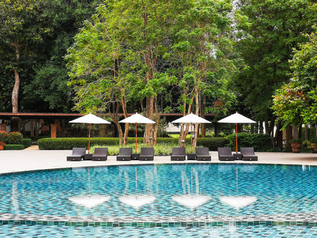 Chairs and umbrellas by the pool With reflectionの写真素材