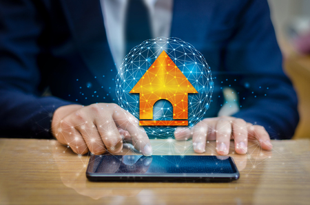 The house is in the hands of the business man  home icon or symbolの写真素材