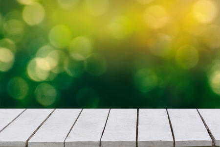 natural green background with selective focus. The green background has a bokeh leaf and grass on a white wooden floor.の写真素材