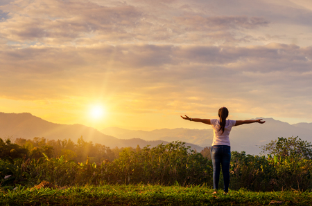 Beautiful Young Girl Against Sunset Feeling the morning freshness and feeling the freedomの写真素材