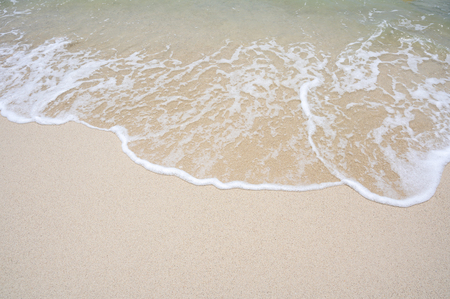The top corner of the beach has a sea of water coming to the shoreの写真素材