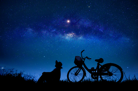 The person is cycling in the midst of the stars galaxyの写真素材