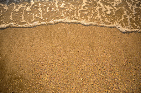 The top corner of the beach has a sea of water coming to the shoreの写真素材