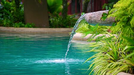 Water flowing water falling into the pond, decoration of the edge of the pooの写真素材