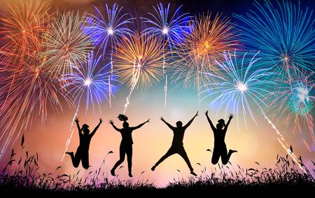 A group of teens jumping with fun and watching the fireworksの写真素材