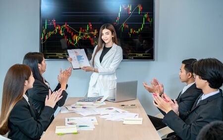 A group of business people meeting and applauding the leaderの写真素材