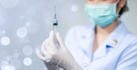 The doctor put on a mask and was injecting with coronavirus covid-19.の写真素材