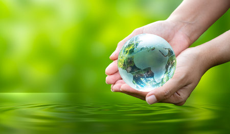 Concept Save the world save environment The world is in the grass of the green bokeh backgroundの写真素材