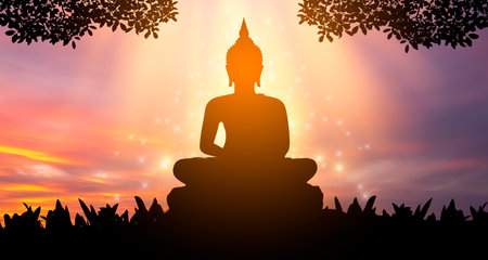 Buddha statue Silhouette Buddha sitting on lotus flower on orange backgroundの写真素材
