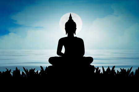 Buddha statue Silhouette Buddha sitting on lotus flower on  Sky and moon on blue backgroundの写真素材