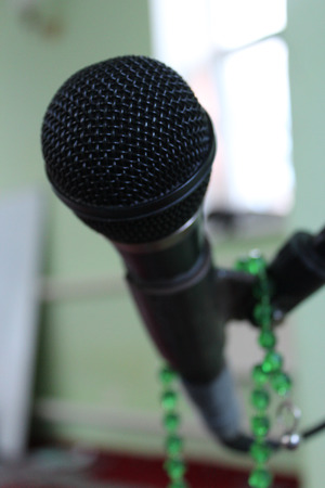 Microphone on a green background and rosaryの写真素材