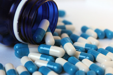 Blue and
 tablets in a jar and around a jar of medicineの写真素材