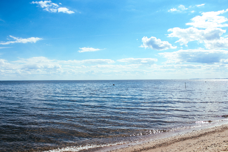 Summer sea waves and sky in the cloudsの写真素材
