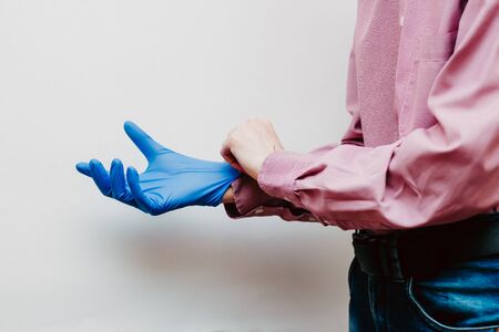 The guy puts on medical glovesの写真素材