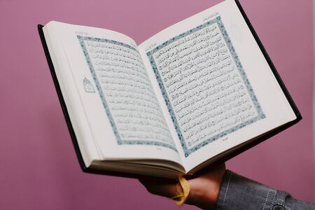 The Quran is in the hands of a guy. Close planの写真素材