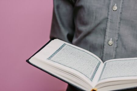 The Quran is in the hands of a guy. Close planの写真素材