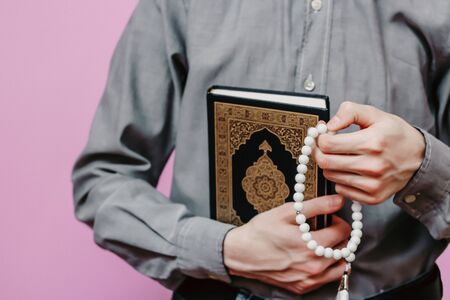 Guy holds Quran and Islamic rosaryの写真素材