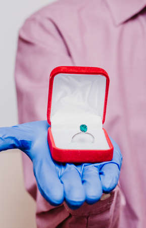 Man in medical mask and gloves with engagement ring.