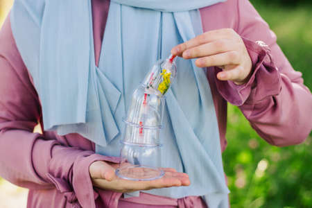 The girl is holding a jar for hijama. Hijama, bloodletting, treatment of sunna. Jars for...