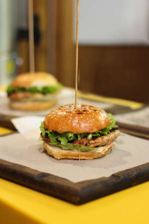 Burgers with lettuce, cutlet and tomatoes. Burgers in the restaurant. Burgers close up. Fast food, wrong food. Fat. Obesityの写真素材
