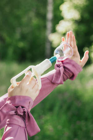 The girl holds in her hands jars for hijama and a pump. Bloodletting. Muslim hijam. The doctor who does the bloodletting. Flowers Sunnah treatment. Muslim girl in a pink dress. Hijab.の写真素材