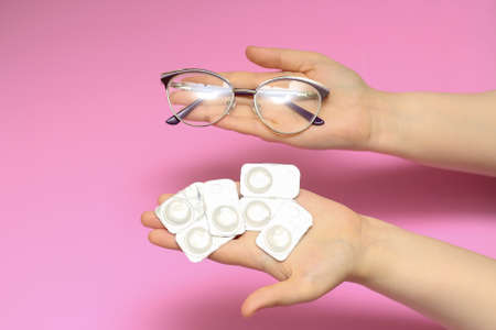 Glasses and contact lenses on a pink background. Vision correction. Glasses for sight. Glasses or...
