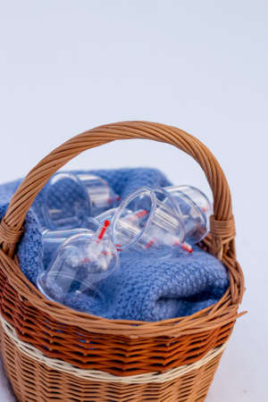 Jars for hijama in a basket in the snow. Wicker basket. Bloodletting according to the Sunnah. Vacuum therapy. medical and health concept. Winter and snow.の写真素材