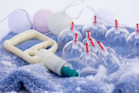 Jars for hijama on a knitted blue plaid in the snow in the forest. Vacuum therapy. Bloodletting according to the Sunnah. Chinese medicine.の写真素材