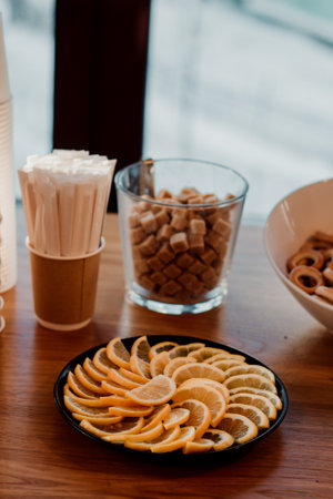 Sliced lemon wedges on a plate. Brown sugar in the background.の写真素材