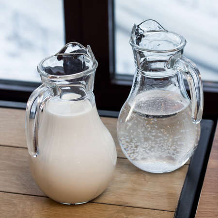 Two jugs. One with water and one with milk. Pitchers on the tableの写真素材