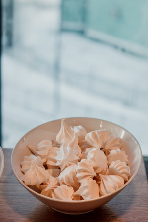 White meringues in a beautiful white plate on the tableの写真素材