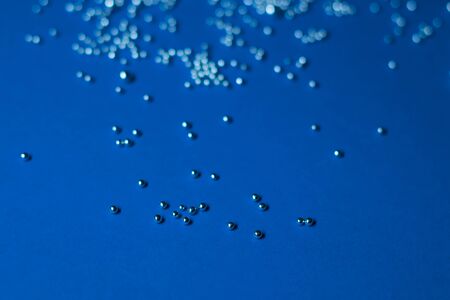 A lot of silver little balls on a blue background. Horizontal photoの写真素材