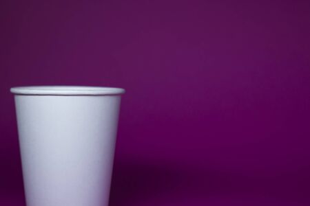 An empty white paper cup on a pink background. horizontal photo. の写真素材