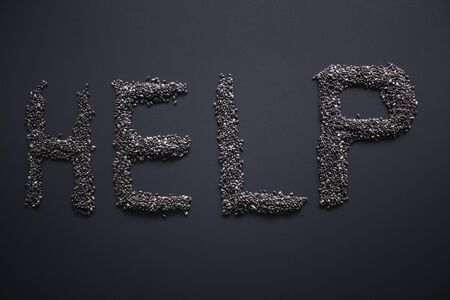 Word HELP written with chia seeds on gray background, top view, copy space.の写真素材