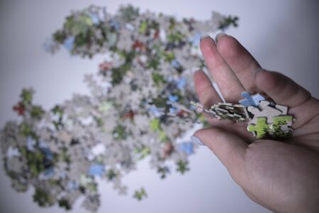 hand holding multicoloured puzzles on a white background. isolated. Top view, copy space.の写真素材