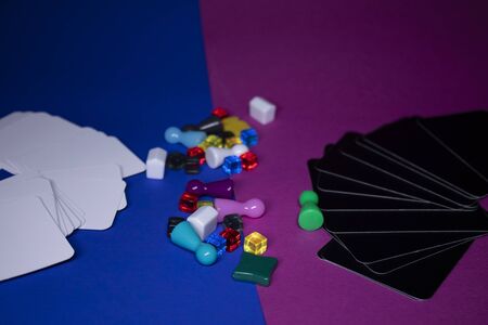 Elements - attributes for board games - figures, cards, cubes, bottles, points, houses. On pink and blue background. Isolated. Copy space. Exciting time with friends during isolation and quarantineの写真素材