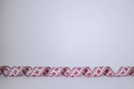 Red measuring tape on white background. Loss weight concept. Top view. Copy space. Isolated. . High...